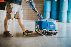 Man using automatic scrubber to clean concrete floor